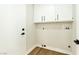 Laundry room with white cabinets and wood-look floors at 1724 Navajo Lake Way, Las Vegas, NV 89128