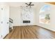 Living room with wood floors, marble accent wall with modern fireplace and a ceiling fan at 1724 Navajo Lake Way, Las Vegas, NV 89128