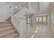 Bright foyer with tile floors, a staircase with glass railings, and an abundance of natural light at 1812 Relate Ct, Las Vegas, NV 89117