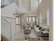 Staged living room with a soaring ceiling, tile floors, large windows, and modern furniture at 1812 Relate Ct, Las Vegas, NV 89117