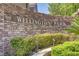 Stone sign at Wellington Park, surrounded by manicured landscaping and lush greenery at 1812 Relate Ct, Las Vegas, NV 89117