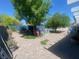 Expansive backyard featuring mature trees, landscaping, and a charming brick patio at 1841 Skywood Way, Las Vegas, NV 89142
