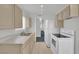 Well-lit kitchen featuring neutral cabinets, white appliances, and laminate flooring, ready for modern updates at 2016 Linden Ave, Las Vegas, NV 89101