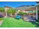 Inviting backyard featuring manicured turf, a covered patio, and a pergola-covered outdoor seating area at 2189 De Narvik Dr, Henderson, NV 89044