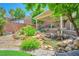 Serene backyard pond with lush landscaping and a covered patio for relaxing and enjoying the outdoors at 2189 De Narvik Dr, Henderson, NV 89044