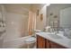 Cozy bathroom featuring a shower-tub combo, wood vanity, and decorative mirror at 2189 De Narvik Dr, Henderson, NV 89044