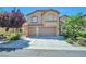 Charming two-story home featuring a well-manicured lawn, two-car garage, and classic desert landscaping at 2189 De Narvik Dr, Henderson, NV 89044