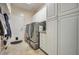 Well-organized laundry room with modern washer and dryer, cabinets, and convenient access to the outside at 2189 De Narvik Dr, Henderson, NV 89044