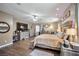 Spacious main bedroom featuring wood floors, a ceiling fan, and a large dresser and mounted TV at 2189 De Narvik Dr, Henderson, NV 89044