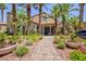 The beautiful clubhouse is surrounded by lush landscaping and a stone walkway at 2300 E Silverado Ranch Blvd # 1165, Las Vegas, NV 89183