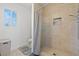 Tiled bathroom featuring a walk-in shower, a window, and neutral decor at 2639 Regency Cove Ct, Las Vegas, NV 89121