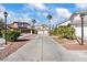 Long driveway leading to the home, complemented by desert landscaping, mature palms, and street lamps at 2639 Regency Cove Ct, Las Vegas, NV 89121