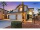 Charming two-story home featuring a three-car garage, stone accents, and manicured landscaping at 2639 Regency Cove Ct, Las Vegas, NV 89121