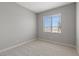 Clean bedroom with neutral carpet, base molding, gray walls and a window to the outside at 3232 Lahontan St, North Las Vegas, NV 89032
