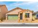Charming single-story home featuring a green garage door, low maintenance landscaping, and a brick driveway at 3232 Lahontan St, North Las Vegas, NV 89032
