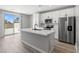 Stylish kitchen features quartz countertops, stainless steel appliances, white cabinets, and a sliding glass door at 3232 Lahontan St, North Las Vegas, NV 89032