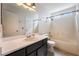 Bright bathroom featuring a single sink vanity, large mirror, and a shower-tub combo at 350 S Durango Dr # 108, Las Vegas, NV 89145