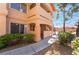 Low angle view of the exterior of the two-story residential building and landscaped walkway at 350 S Durango Dr # 108, Las Vegas, NV 89145