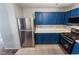 Bright kitchen with blue cabinetry, stainless steel appliances, tile flooring, and a clean, efficient layout at 350 S Durango Dr # 108, Las Vegas, NV 89145