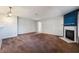 Bright, carpeted living room featuring a minimalist fireplace, neutral wall colors, and a contemporary light fixture at 350 S Durango Dr # 108, Las Vegas, NV 89145