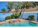 Close up on the hot tub, showing rock details, with muraled block wall and lush landscaping at 3832 Alder Creek Ct, North Las Vegas, NV 89032