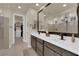 Elegant bathroom featuring double sinks, a large mirror, and a spacious walk-in shower at 40 Vicolo Della Luna, Henderson, NV 89011