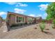 Back exterior view of home surrounded by desert landscape and covered patio at 40 Vicolo Della Luna, Henderson, NV 89011