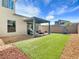 Well-maintained backyard with lush artificial turf, a covered patio, and gravel landscaping at 4246 W Landberg Ave, Las Vegas, NV 89141