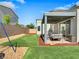 Well-maintained backyard featuring a covered patio, lush artificial turf, and gravel landscaping at 4246 W Landberg Ave, Las Vegas, NV 89141