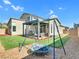 Spacious backyard with artificial turf, a covered patio, and a swing set; perfect for outdoor entertainment at 4246 W Landberg Ave, Las Vegas, NV 89141