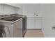 Laundry room with stainless steel washer and dryer and sink with storage at 4246 W Landberg Ave, Las Vegas, NV 89141