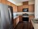 Modern kitchen with stainless steel appliances, wood cabinets, and granite countertops at 4554 Townwall St, Las Vegas, NV 89115