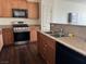 Kitchen area featuring granite counters, a stainless steel double sink and wood cabinets at 4554 Townwall St, Las Vegas, NV 89115