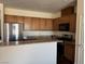 Kitchen area showcasing wooden cabinets, granite countertops, and stainless steel appliances at 4554 Townwall St, Las Vegas, NV 89115