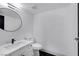 Sleek powder room with modern sink, round mirror, and black tile accents, offering a stylish design at 4571 Sirius Ave, Las Vegas, NV 89102