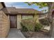 The exterior of a well-maintained townhome showcasing a brown front door and mature landscaping at 4571 Sirius Ave, Las Vegas, NV 89102