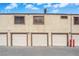 Row of well-maintained garages with light-colored doors and textured siding under a blue sky at 5029 Spencer St # D, Las Vegas, NV 89119