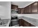 Modern kitchen featuring stainless steel appliances, granite countertops, and stylish cabinets at 5029 Spencer St # D, Las Vegas, NV 89119