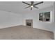 A spacious room with a ceiling fan, and fireplace, enhanced by natural light and tile flooring at 5029 Spencer St # D, Las Vegas, NV 89119