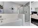 A bathroom with a shower and large garden style tub, alongside glass shower door and tiled walls at 5171 Briar Patch Way, Las Vegas, NV 89118