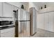 Kitchen featuring stainless steel refrigerator and appliances adjacent to white pantry and cupboard at 5171 Briar Patch Way, Las Vegas, NV 89118