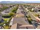 Real estate aerial view featuring tile roofs, solar panels, neighborhood streets and mountain backdrop at 6141 Markleham Ave, Las Vegas, NV 89130