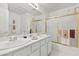 Bright bathroom featuring dual sinks, white cabinets, and gold shower at 6141 Markleham Ave, Las Vegas, NV 89130