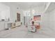 Dining area with elegant white cabinetry, modern chandelier, and glass table with orange seat cushions at 6141 Markleham Ave, Las Vegas, NV 89130