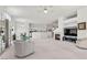 Bright living room with fireplace, ceiling fan, and open floor plan to kitchen at 6141 Markleham Ave, Las Vegas, NV 89130