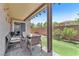 Backyard patio area with an outdoor seating area, lush grass, and a brick wall at 7115 Hickory Post Ave, Las Vegas, NV 89179