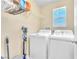Functional laundry room with a modern washer and dryer set and storage shelving at 7115 Hickory Post Ave, Las Vegas, NV 89179