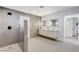 Bathroom featuring a modern shower, hexagon mirrors, a double sink vanity, and tiled floors and walls at 7140 Palmyra Ave, Las Vegas, NV 89117