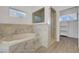 Luxurious bathroom featuring a soaking tub with marble surround and walk-in closet at 7140 Palmyra Ave, Las Vegas, NV 89117