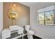 Stylish powder room featuring a unique mirror, elegant vanity, and a window with a view at 7140 Palmyra Ave, Las Vegas, NV 89117
